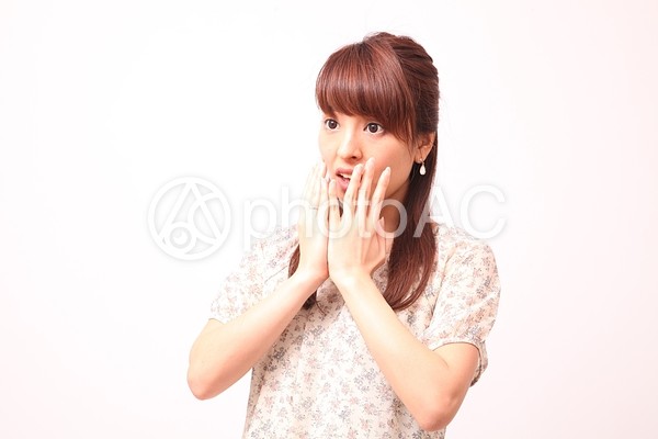 驚きながら両手で口を覆う女性2 驚きながら両手で口を覆う女性2の写真
