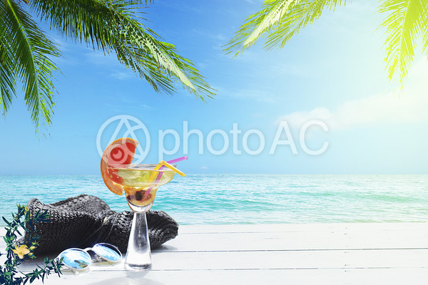 飲み物と帽子とサングラスが置いてある海辺のリゾート 飲み物と帽子とサングラスが置いてある海辺のリゾートの写真